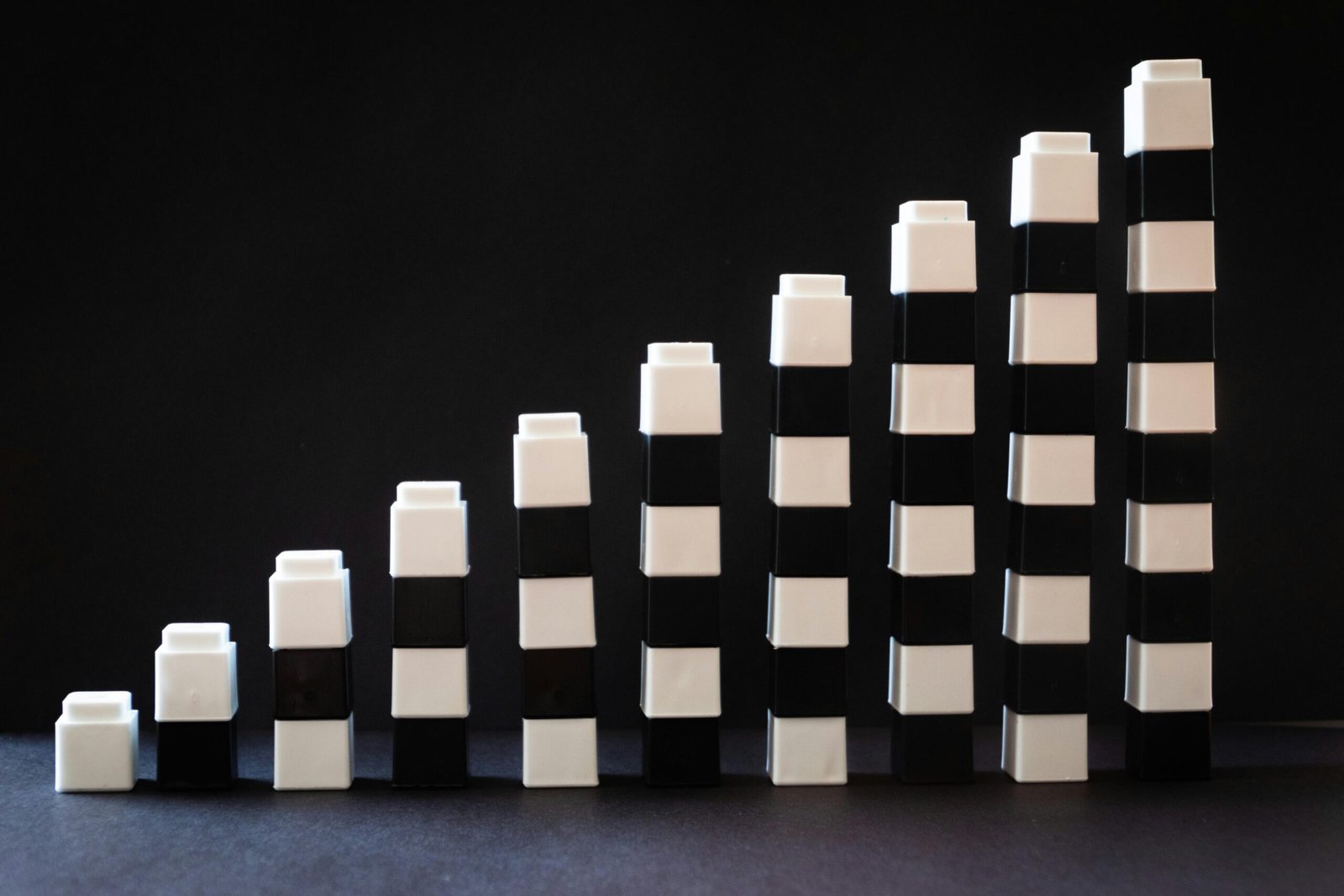 Black and white toy blocks arranged in ascending order to symbolize growth or progress.